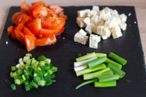 Tomaten, Frühlingszwiebeln, Feta schneiden