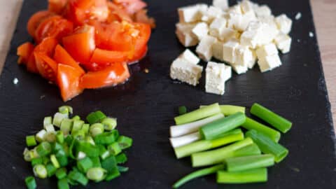 Tomaten, Frühlingszwiebeln, Feta schneiden