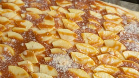 Karamellcreme auf Apfel Blechkuchen verteilen