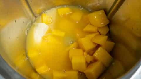 Mango und Orangesaft im Mixtopf