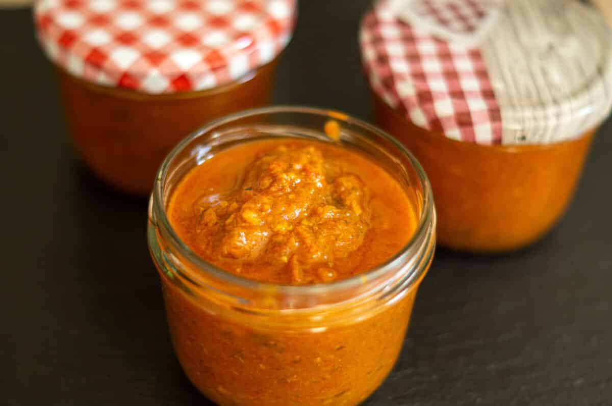 Tomaten-Dattel-Chutney in sterile Einmachgläser abfüllen