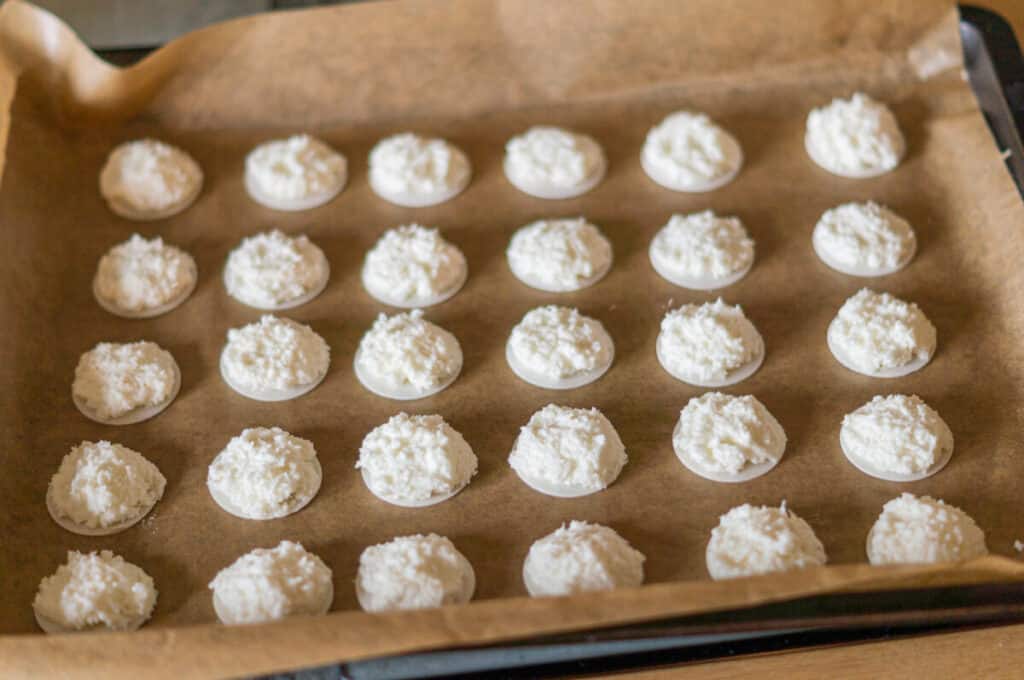 Die Kokosmakronen werden auf einem Backblech zum Backen vorbereitet