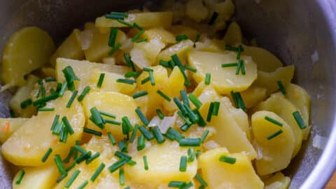 Kartoffelsalat mit Schnittlauch bestreuen