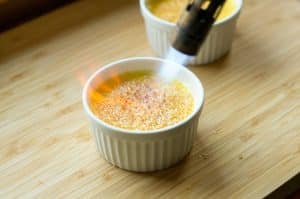 Crème brûlée flambieren um Zucker zu karamellisieren