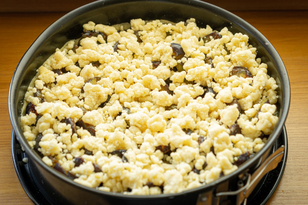 Zwetschgenkuchen aus dem Thermomix® 16 streusel ueber zwetschgenkuchen verteilen