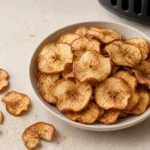 Knusprige Apfelchips aus der Heißluftfritteuse in einer hellen Schale